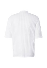 Chemise en maille blanche à manches courtes avec côtes verticales texturées et col rond, vue de dos sur fond blanc.