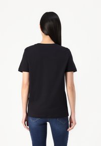Black cotton t-shirt with short sleeves and a round neckline, featuring a straight cut and no visible logos or patterns.