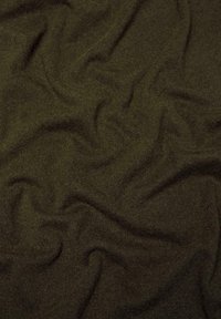Tissu en tricot vert olive foncé avec une texture douce, présentant un motif légèrement ondulé qui indique un drapé et une flexibilité.