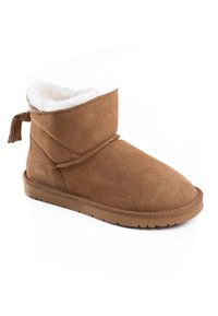 Stivale alla caviglia in suede marrone foderato in morbido pelliccia bianca, con suola piatta in gomma. Presenta un tassello decorativo sul retro.