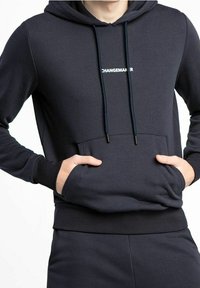 Felpa blu navy in morbido tessuto con tasca a marsupio, cappuccio regolabile con cordino, e testo "CHANGEMAKER" in bianco. Polsini e orlo testurizzati.