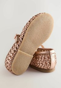 Metalliska roséguld flätade ballerinas med en jämn, texturerad sula. Har en ankelrem och mjukt, flexibelt material för komfort.