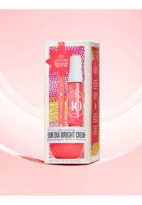 Sol de Janeiro Bom Dia Bright kremsett, som inneholder en livlig rosa flaske, hvit pumpe og en fargerik mønstret eske med produktdetaljer.