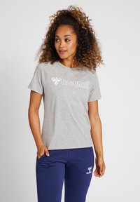 Grijze T-shirt met korte mouwen en een wit logo, gecombineerd met marineblauwe broeken met een bijpassend logo. De stof lijkt zacht en geschikt voor casual kleding.