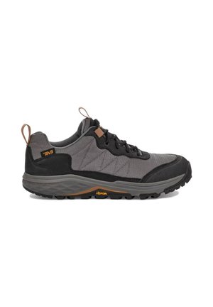 Scarpa da trekking grigia e nera a taglio basso con chiusura frontale con lacci, suola testurizzata e linguette sul tallone e sulla linguetta, con i loghi Teva e Vibram.
