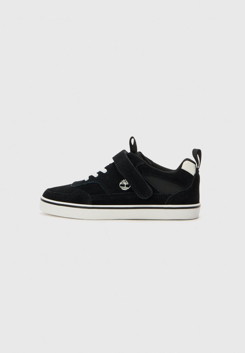 Svarte semskede sneakers med hvit gummisåle, borrelåsrem og snøredetaljer; har en logo på siden og kontrasterende hælflik.