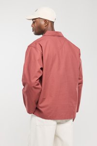 Losse, lange mouwen blouse in koraal, gemaakt van katoen. Kenmerkt zich door een puntig kraag en een gesplitste rug yoke ontwerp. Gepaarde met lichtbeige broek.