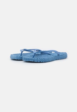 Een paar blauwe, gestructureerde teenslippers met dunne bandjes, naast elkaar geplaatst op een eenvoudige witte achtergrond.