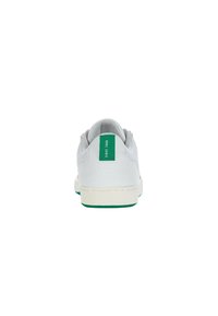 Fehér sneaker, texturált felsőrésszel, zöld díszítéssel a sarkán és dombornyomott logóval a hátulján. Lapos fehér talp zöld szegéllyel.