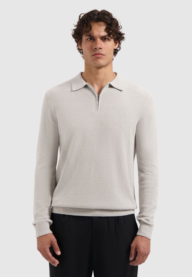 Hellgrauer Pullover mit strukturiertem Muster, Kragen und Reißverschlussleiste. Taillierte Form mit gerippten Bündchen und Saum.