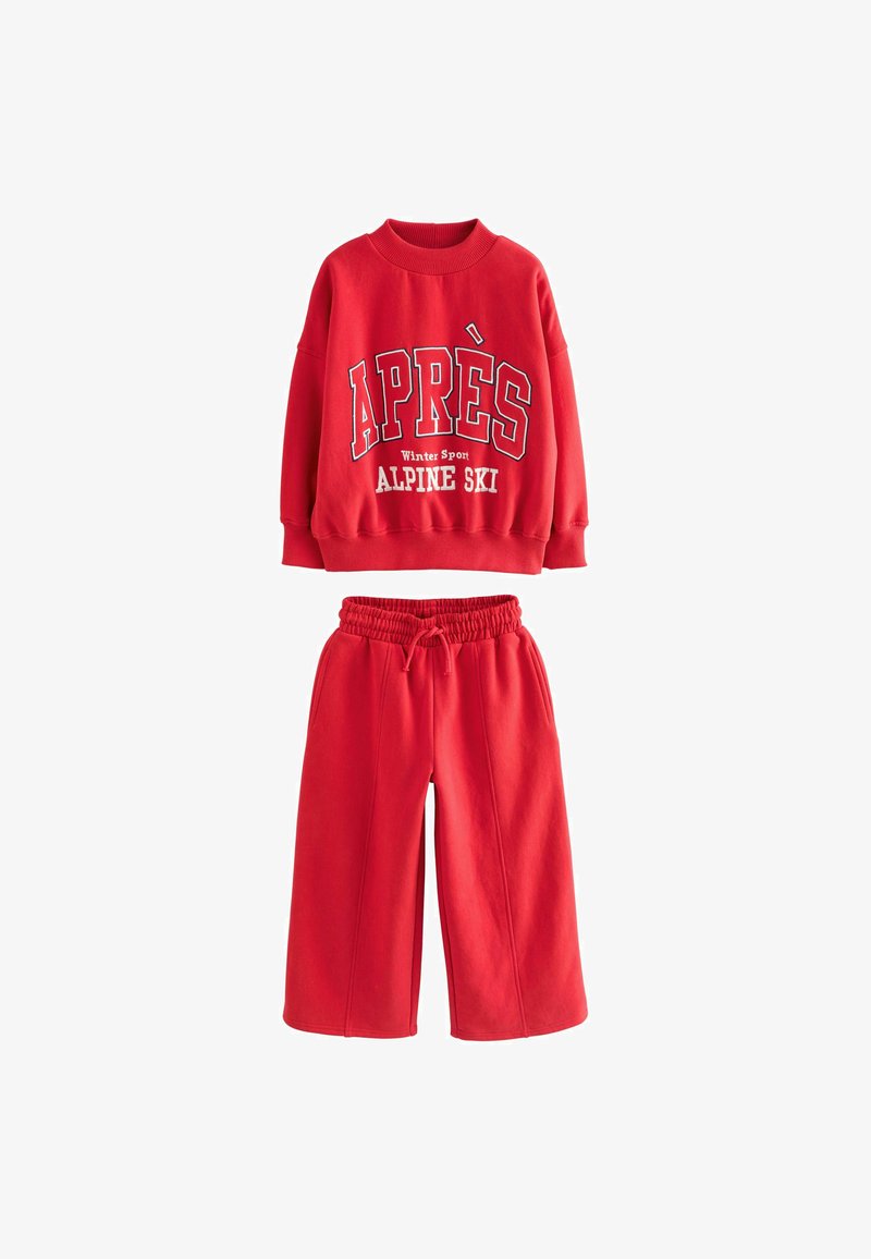 Red sweatshirt with "APRÈS Winter Sport ALPINE SKI" graphic, paired with matching red, elastic-waist wide-leg pants. Soft fabric, casual design.