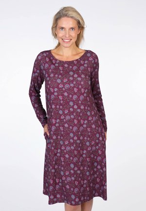 Langärmliges Kleid in Burgunderrot mit floralem Muster in Blau und Pink. Verfügt über seitliche Taschen und einen runden Ausschnitt. Weicher Stoff.
