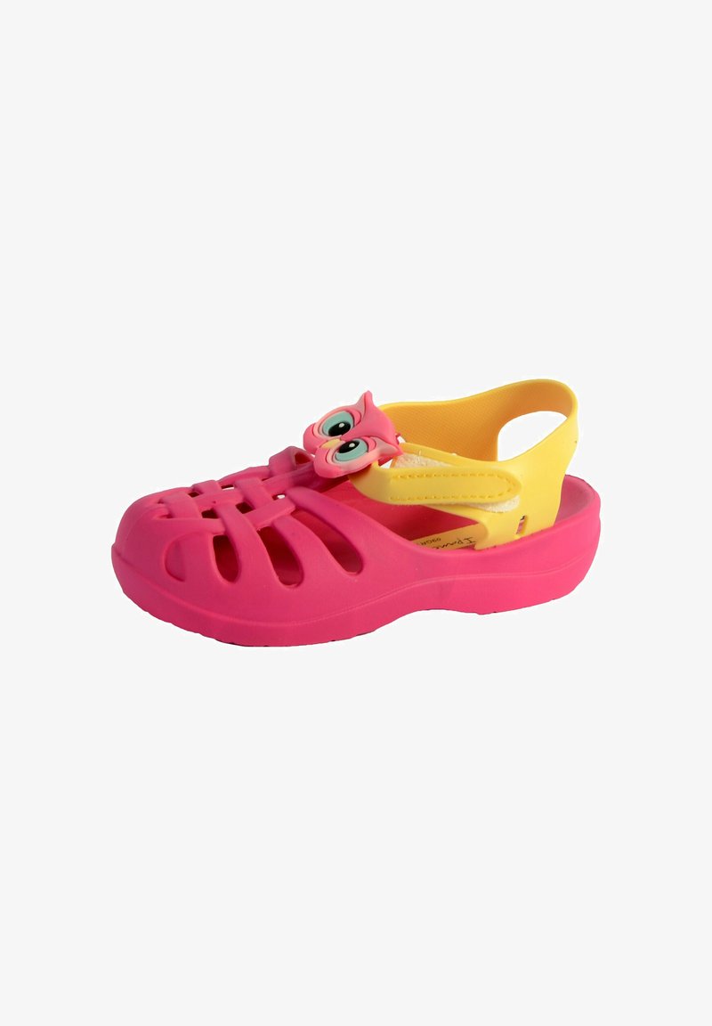 Pink plastic clogs with cut-out vents and a yellow back strap. Features an owl-shaped accent on the front, with large eyes and a playful design.