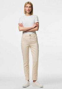 Beezid puuvillased püksid sirge jala ja nupuga sulgemisega, vöölõngad ja ees taskud. Kaasatud valged tossud.