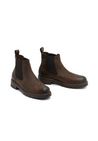 Botas Chelsea de cuero marrón con paneles laterales elásticos, punta redondeada y suela de goma texturada; lengüetas en el talón para un fácil uso.