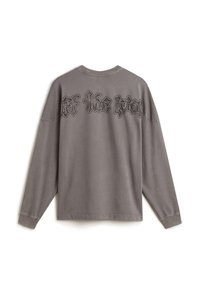 Šedé tričko s dlouhým rukávem a kulatým výstřihem. Na horní části zad má černý gotický text. Hladká tkanina s volným střihem a žebrovanými manžetami.