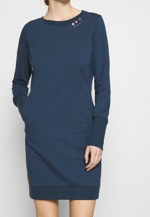 Mørkeblå langærmet kjole lavet af blød bomuld. Har en rund halsudskæring, sidelommer og dekorerende knapper nær skulderen.