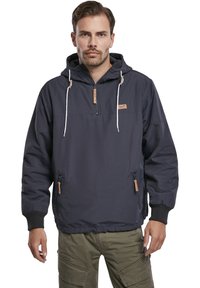 Chaqueta de pullover azul marino con media cremallera, capucha ajustable, bolsillos laterales, puños elásticos y detalles de cuero en contraste. Tejido ligero.