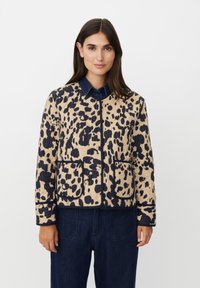 Giacca trapuntata beige con grande stampa leopardata blu navy, caratterizzata da un collo rotondo, due tasche anteriori e una finitura in blu navy a contrasto.