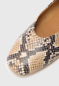 Ballerina-Flachschuh mit Schlangenledermuster in Beige-, Braun- und Schwarztönen. Abgerundete Spitze, glatte Textur und offenes Seitendesign.