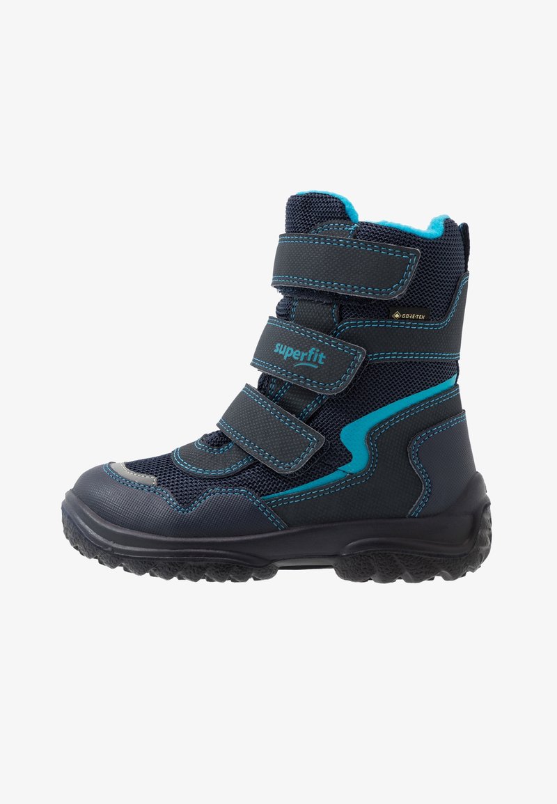 Botte d’hiver enfant noire et bleue avec trois bandes Velcro, semelle robuste, coutures bleues et matériau imperméable Gore-Tex.