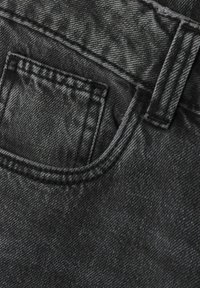 Svart denimtyg har en framficka med sömmar och en mjuk yta som visar en subtil lyster och en klassisk design.
