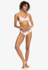 Bikini-set met een bloemenprint in roze, groen en wit. De top heeft dunne bandjes en een driehoekige vorm, terwijl de onderkant een hoog uitgesneden stijl heeft.