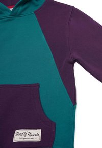 Hoodie med en lila och grön färgblockdesign, som har en framficka och en vävd etikett på fållen. Mjuk, elastisk tyg.