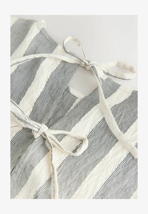 Hvidt stof med marineblå striber, med en bindedetalje ved halsudskæringen. Teksturen virker let krøllet, hvilket tilføjer visuel interesse.