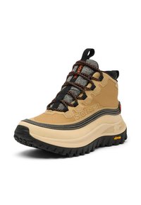 Botte imperméable de couleur fauve avec des accents noirs et gris, tige en tissu texturé, semelle Vibram, avec des rayures hexagonales et des lacets orange.