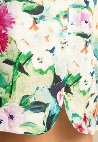 Gėlėmis margintas audinys baltos, žalios, rožinės ir mėlynos spalvų atspalviais; lengvos, kvėpuojančios tekstūros; turi lenktą apatinę kraštą su švelniu įpjovimu.