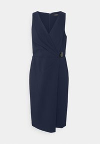 Marinblå ärmlös klänning med V-ringning, sammanknuten framtill och diagonal skärning. Har ett metallaccent vid midjan och dragkedjestängning bak.