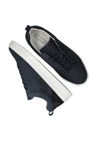 Marineblauwe suède sneakers met witte rubberen zolen, voorzien van een vetersluiting, ronde neus en een handvat op de hiel voor gemakkelijk aan- en uittrekken.