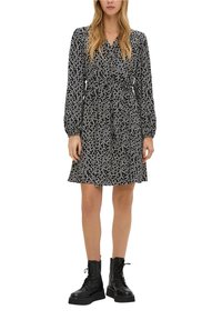 Černé šaty s bílým květinovým potiskem, dlouhé rukávy a stáhnutý pas. Kombinováno s černými, šněrovacími bojovými botami. Hladká textilie.