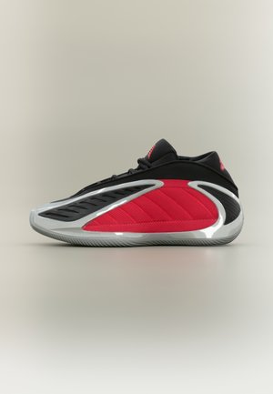 Baskets de sport rouges et noires au design élégant, tige en mesh, panneau rouge texturé et semelle argentée brillante avec des rainures.