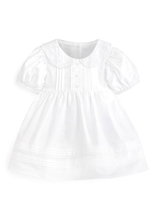 Robe blanche pour bébé avec manches ballon, col Peter Pan bordé de dentelle, devant boutonné, et plis décoratifs sur la jupe et le corsage.