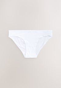 Sous-vêtement féminin en coton blanc style bikini avec un petit nœud au centre avant de la ceinture sur un fond uni.