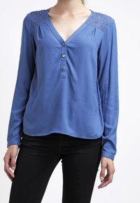 Blue long-sleeve blouse with a V-neck, featuring lace accents on shoulders, button detail at the front, and soft fabric texture.