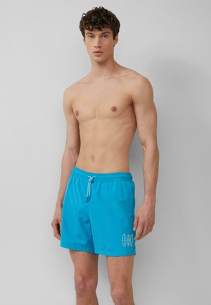Shorts de bain bleus en tissu léger, dotés d'une taille élastique avec cordon de serrage et d'accents graphiques blancs minimalistes sur le côté.