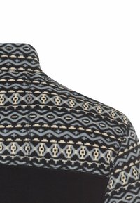 Sort og mønstret fleecepullover med geometriske designs i blå og creme, med en ensfarvet sort sektion i bunden.