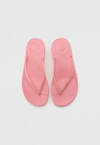 Roza japonka iz gume. Raven podplat s teksturiranim notranjim delom in Y-oblikovanimi naramnicami. Enostavna zasnova brez dodatnih vzorcev ali okrasnih elementov.