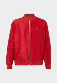 Punane pommikjakker, millel on sile kangas, esitõmbliku, ribitud kaelus ja mansetid ning küljetaskud. Väike logode detail rinnal.