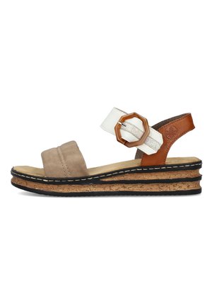 Sandale en suede marron et cuir blanc avec une boucle octogonale, semelle intermédiaire en liège et semelle extérieure en caoutchouc noir, présentant des détails de design superposés.
