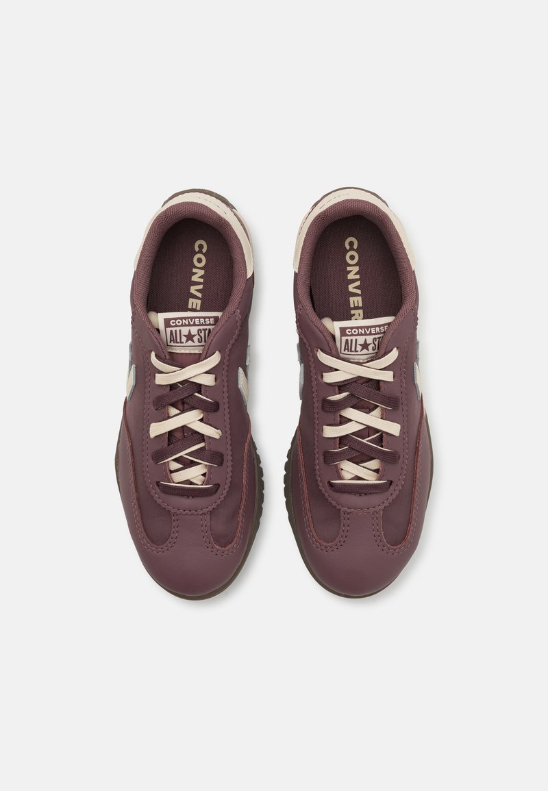 Zapatillas de cuero burdeos con cordones y detalles en crema, presentando un diseño de punta redonda, suelas texturizadas y la marca "Converse All Star".