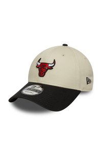 Beige honkbalpet met een zwarte rand, voorzien van een rode geborduurde Chicago Bulls-logo aan de voorkant en een verstelbare band aan de achterkant.