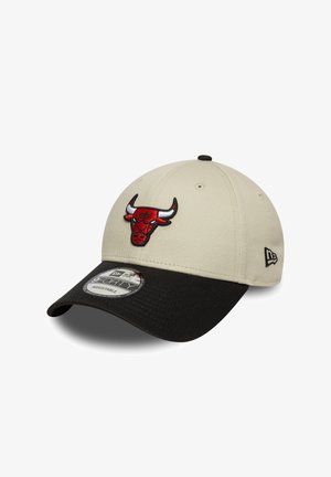 Cappellino da baseball beige con visiera nera, che presenta un logo ricamato rosso dei Chicago Bulls sulla parte anteriore e una cintura regolabile sul retro.