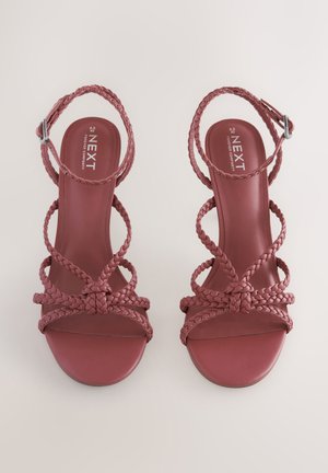 Červené pletené sandále na opätku s otvorenou špičkou a remienkom okolo členku, s hladkou matnou podrážkou a preplietanými remienkami pre oporu.