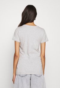 Grå bomulls t-shirt med kort ärm, rund halsringning och en figurnära passform. Slät yta utan synliga mönster eller detaljer.