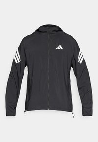 Zwarte windjack met een ritssluiting aan de voorkant, een capuchon en witte drie-strepen accenten op de mouwen. Gemaakt van lichtgewicht, gladde stof.