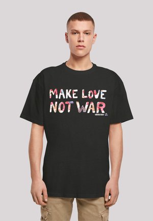 Black cotton t-shirt featuring multicolored text saying "MAKE LOVE NOT WAR" in a bold, blocky font, paired with beige cargo shorts.